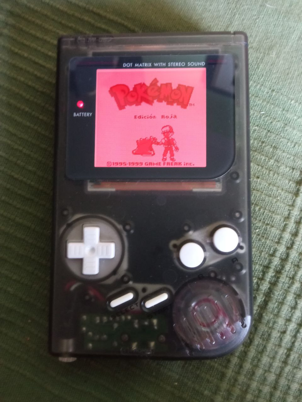 Modded Nintendo DMG console with a clear black case, white buttons and a backlit screen in red