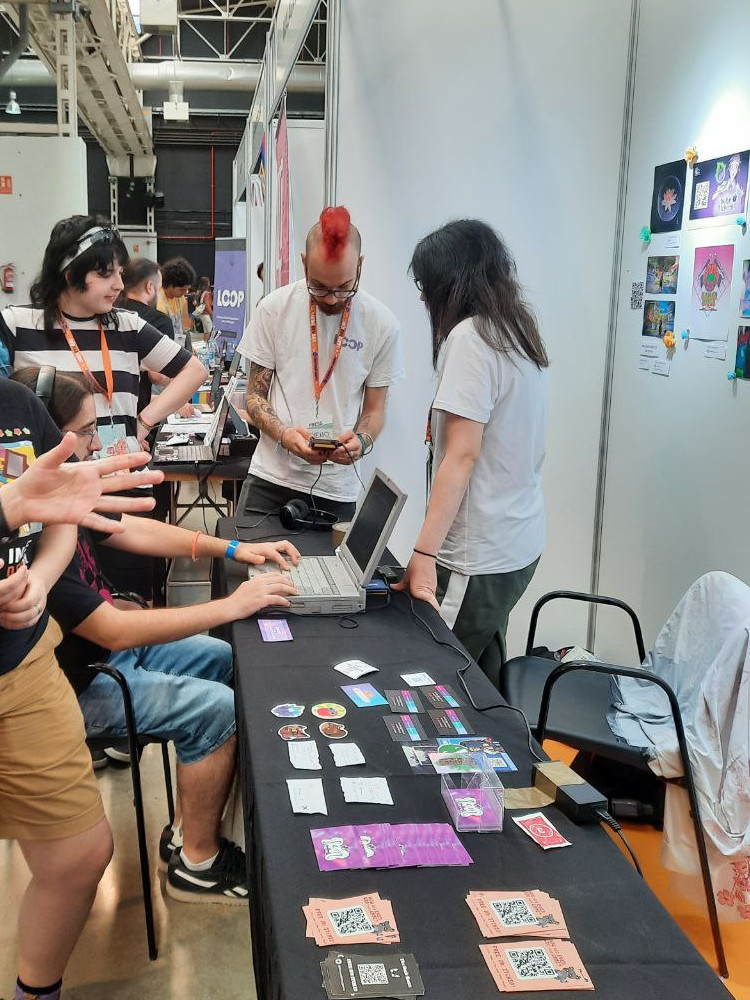 People trying out the game on the laptop and on a Game Boy during the event. 